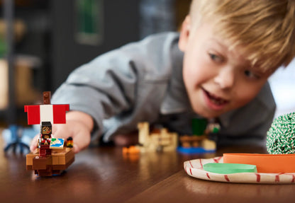 Child playing with a toy pirate ship on a wooden table